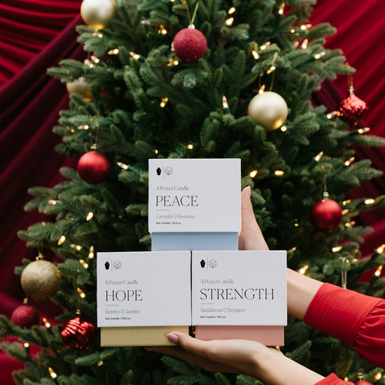 a person holding a sign in front of a christmas tree