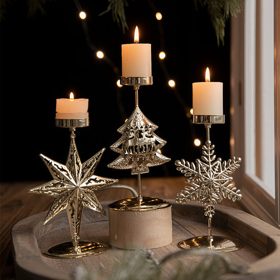 Retro Iron Christmas candlestick decorations with star, tree, and snowflake designs, featuring lit candles.